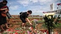 Mereka menaburkan bunga, berdoa, dan membersihkan makam keluarga.