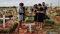 Rasa haru terlihat saat mereka memanjatkan doa di makam keluarga.