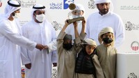 Peternak unta pemenang menerima piala untuk unta mereka di Festival Al Dhafra di daerah gurun Liwa 120 kilometer (75 mil) barat daya Abu Dhabi, Uni Emirat Arab.