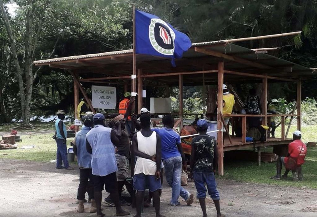Warga memegang bendera Bougainville di tempat pemungutan suara selama referendum kemerdekaan yang tidak mengikat di Arawa, di pulau Bougainville, Papua Nugini, (26/19). (REUTERS/Melvin Levongo/File Foto) Warga memegang bendera Bougainville di tempat pemungutan suara selama referendum kemerdekaan yang tidak mengikat di Arawa, di pulau Bougainville, Papua Nugini, (26/19). (REUTERS/Melvin Levongo/File Foto)