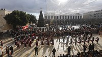 Kelompok pemusik menjadi bagian dalam peringatan Natal di Jalur Barat, Betlehem, Palestina (24/12).  (AP Photo/Mahmoud Illean)