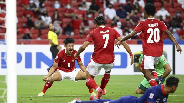 Witan Sulaeman of Indonesia, left, celebrates with Ezra Harm Ruud Walian, second left, after scoring the first goal during the AFF Suzuki Cup 2020 semi-final second leg match between Indonesia and Singapore in Singapore, Saturday, Dec. 25, 2021. (AP Photo/Suhaimi Abdullah)