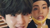 Suga dan V tampak berpose bersama saat menikmati jus jeruk pemberian penggemar mereka. Foto: dok. Big Hit