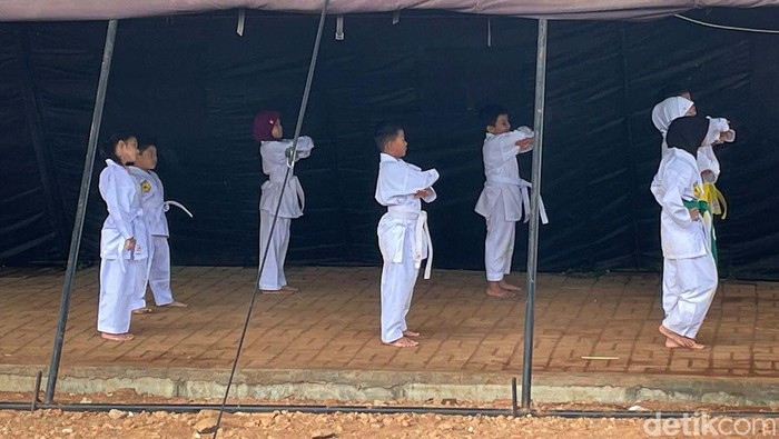 Sejumlah anak berlatih beladiri karate di kolong Tol Becakayu, Jakarta Timur. Mereka berlatih di tenda pengungsian untuk korban banjir.