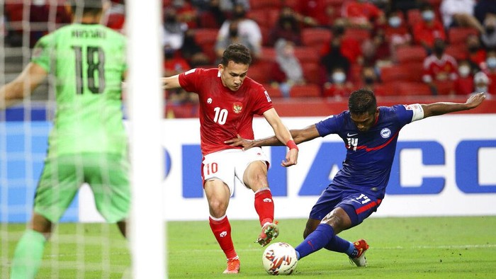Hariss Harun of Singapore, right, and Egy Maulana Vikri of Indonesia compete for the ball during the AFF Suzuki Cup 2020 semi-final second leg match between Indonesia and Singapore in Singapore, Sunday, Dec. 26, 2021. (AP Photo/Suhaimi Abdullah)