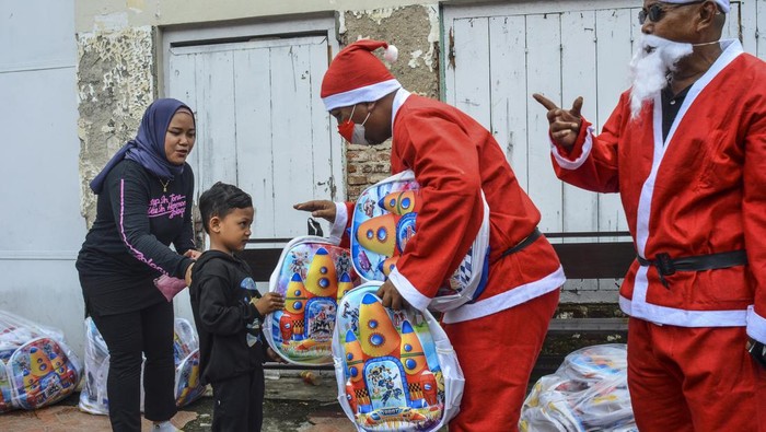 Ho Ho Ho.. Santa Bagi-bagi Hadiah Natal di Jalanan Warga berpakaian