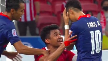 Kegagalan penalti pemain Singapura Faris Ramli yang ditepis Nadeo, bisa dibilang sebagai salah satu momen kunci di laga Indonesia vs Singapura Piala AFF 2020. Usai Faris Ramli gagal penalti, pemain Indonesia Asnawi langsung menghampirinya, dan sepertinya sedikit memprovokasi. Entah apa yang dibilang Asnawi kepadanya, yang jelas momen itu memicu beragam reaksi dan meme kocak dari netizen Indonesia. Foto: Twitter