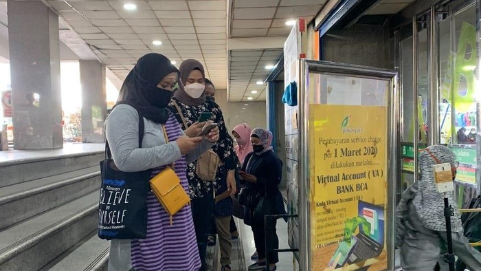 Pengunjung Pasar Tanah Abang wajib scan PeduliLindungi sebelum masuk, Minggu (26/12/2021).