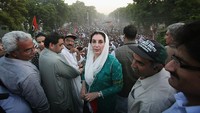 Benazir Bhutto berpose kepada jurnalis di depan para pendukungnya dari Partai Rakyat Pakistan (PPP) di Karachi, (18/10/2007).  Dalam pidatonya, dia sering mendorong hak perempuan untuk belajar dan bekerja. Benazir Bhutto berharap untuk mengubah cara pandang perempuan di Pakistan. (Photo by Daniel Berehulak/Getty Images)