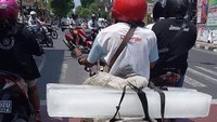 Merasa tak ada yang salah, penjual es batu ini semangat mengirim es batu ke pelanggannya. Menggunakan motor dan terjebak macet di siang hari, kira-kira apakah es batunya masih utuh saat diterima pelanggan? Foto: 1cak/Istimewa