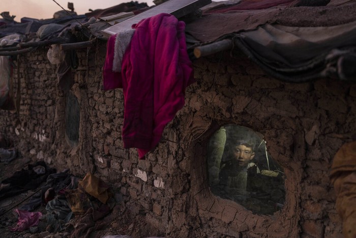 APTOPIX Afghanistan Desperate Times Photo Gallery A child looks out of a window of his home in a neighbourhood where many internally displaced people have been living for years, in Kabul, Afghanistan, Tuesday, Dec. 7, 2021. Since the chaotic Aug. 15 Taliban takeover of Kabul, an already war-devastated economy once kept alive by international donations alone is now on the verge of collapse. There isn't enough money for hospitals. The World Health Organization is warning of millions of children suffering malnutrition, and the U.N. says 97% of Afghans will soon be living below the poverty line. (AP Photo/Petros Giannakouris)