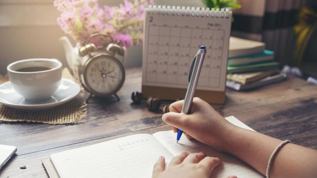 Ilustrasi Jadwal Cuti On 2019 Calendar book,Female'hand of planner writing daily appointment.Woman mark and noted schedule(holiday trip) on diary at office desk.Calendar reminder event for planner concept