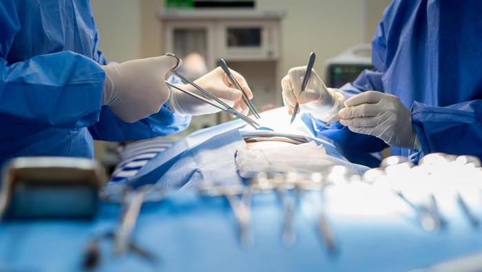 Asian doctor and an assistant in the operating room for surgical venous vascular surgery clinic in hospital.