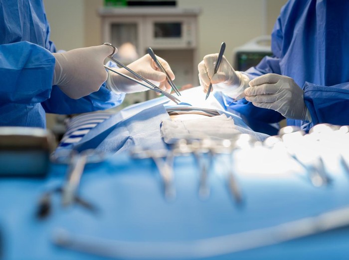 Asian doctor and an assistant in the operating room for surgical venous vascular surgery clinic in hospital.