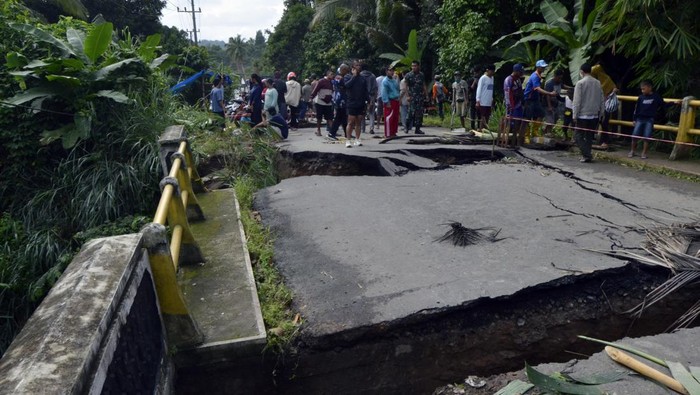 JEMBATAN WAY GEBANG PESAWARAN PUTUS Bupati Pesawaran Dendi Ramadhona (kiri) meninjau kondisi Jembatan Way Gebang yang putus di Desa Gebang, Teluk Pandan, Pesawaran, Lampung, Senin, (27/12/2021). Hujan deras pada Minggu malam (26/12/2021) hingga Senin dini hari menyebabkan Sungai Way Gebang meluap dan mengakibatkan terputusnya jembatan yang menghubungkan Desa Padang Cermin, Batu Menyan, Gebang dan Hanura Pesawaran Lampung. ANTARA FOTO/Ardiansyah/rwa.