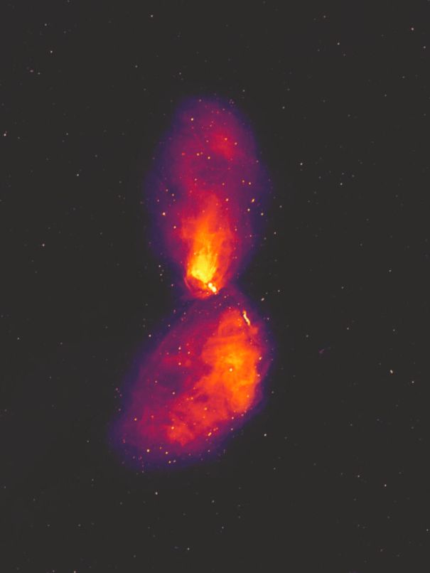 Gambar ini menunjukkan galaksi pada panjang gelombang radio, mengungkapkan lobus plasma yang luas yang mencapai jauh melampaui galaksi yang terlihat, yang hanya menempati sepetak kecil di tengah gambar. Titik-titik di latar belakang bukanlah bintang, tetapi galaksi radio seperti Centaurus A, pada jarak yang lebih jauh.