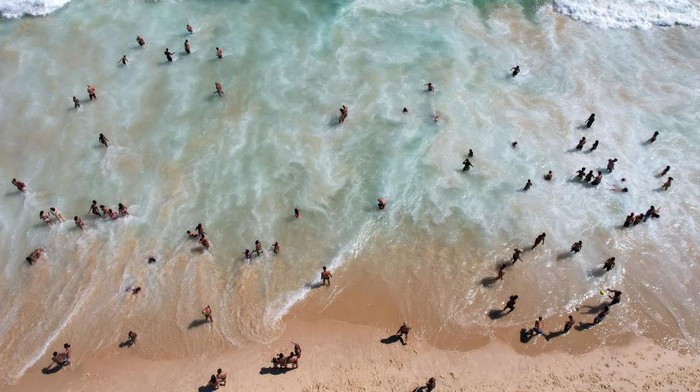RIO DE JANEIRO, BRASIL - 26 DESEMBER: Dalam pandangan udara, orang-orang terlihat di Pantai Ipanema pada 26 Desember 2021 di Rio de Janeiro, Brasil. Pantai-pantai Brasil ramai dengan datangnya musim panas meskipun varian Omicron COVID-19 menyebar ke seluruh dunia. Balai Kota akan mengadakan pesta Malam Tahun Baru di pantai Copacabana, mengambil risiko dari varian baru. (Foto oleh Buda Mendes/Getty Images)