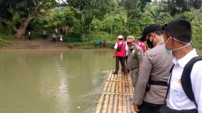 Petugas mengarungi sungai untuk jemput bola vaksinasi di Cianjur