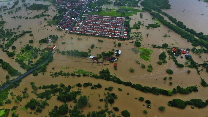 Families place furniture on the roof of their houses due to floods caused by heavy rains in the city of Itapetinga, southern region of Bahia state, Brazil, Sunday, Dec. 26, 2021. The Bahia state government's press office said heavy rains have caused floods that have killed 18 people and affected more than 30 cities since early November, forcing more than 4,000 from their homes and complicating access to some communities. (AP Photo/Manuella Luana)
