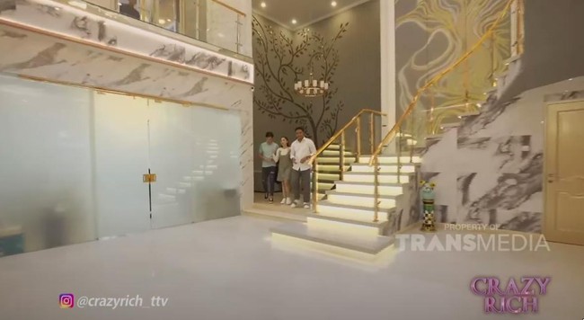 Punya kekayaan melimpah, rumah Crazy Rich Surabaya ini berlapis emas hingga dihiasi kristal Swarovski. Ini potret rumah bling-bling Aswin Yanuar. Berlokasi di sebuah kawasan elit Surabaya, rumah dua lantai ini memiliki luas hingga 1.000 meter persegi. Dinding serta pintu dihiasi ratusan kristal Swarovski warna-warni. Aswin Yanuar mengungkap kalau dia memiliki 135 sertifikat keaslian kristal Swarovski yan digunakan untuk mempercantik rumahnya. (Foto: YouTube TRANS TV OFFICIAL)