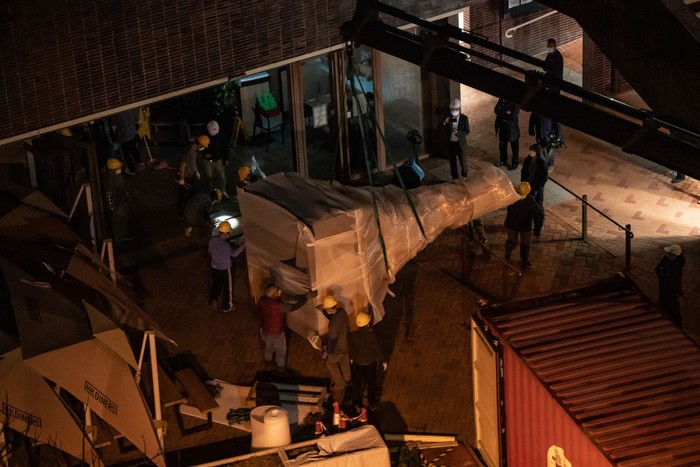 HONG KONG, CHINA - DECEMBER 23: Workers remove part of the 