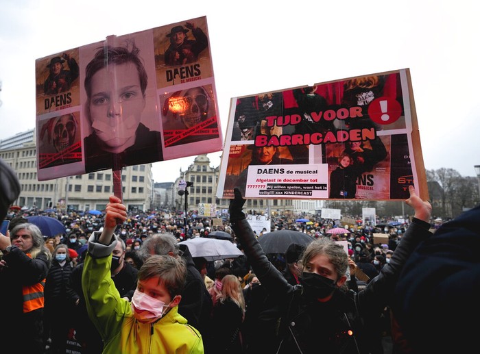 Virus Outbreak Belgium A man holds a sign which reads 'I don't drink Gluhwein' as he protests with other artists during a demonstration in Brussels on Sunday, Dec. 26, 2021. Belgian performers, cinema operators, event organizers and others joined together Sunday to protest the government's decision to close down the country's cultural life to stem the spread of the surging omicron virus variant. Gluhwein refers to a common drink which is served at Christmas markets. (AP Photo/Virginia Mayo)