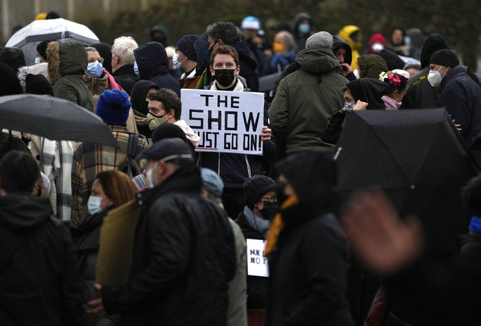Virus Outbreak Belgium A man holds a sign which reads 'I don't drink Gluhwein' as he protests with other artists during a demonstration in Brussels on Sunday, Dec. 26, 2021. Belgian performers, cinema operators, event organizers and others joined together Sunday to protest the government's decision to close down the country's cultural life to stem the spread of the surging omicron virus variant. Gluhwein refers to a common drink which is served at Christmas markets. (AP Photo/Virginia Mayo)