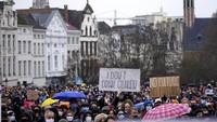 Pendemo memegang poster bertuliskan I dont drink Gluhwein dalam demonstrasi di Ibu Kota Brussel, Belgia (26/12). Gluhwein merupakan minuman alkohol yang populer di Belgia. Pemerintah menutup tempat hiburan untuk menekan penyebaran virus Covid-19 varian Omicron. Kebijakan itu ditentang oleh para pendemo.