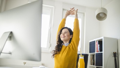Woman stretching and working at home