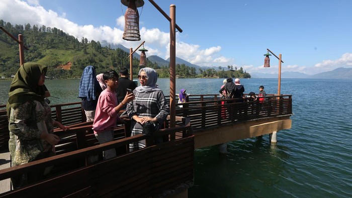 Berkunjung ke Dermaga Pante Menye yang Instagramable Wisatawan mengunjungi dermaga Pante Menye Danau Laut Tawar pada libur natal dan tahun baru di Kecamatan Bintang, Kabupaten Aceh Tengah, Aceh, Minggu (26/12/2021). Bangunan dermaga yang berbentuk perahu dan bermotifkan kerawang gayo yang menjulur ke arah danau menjadi destinasi bagi wisatawan untuk berswafoto. ANTARA FOTO / Irwansyah Putra/foc.