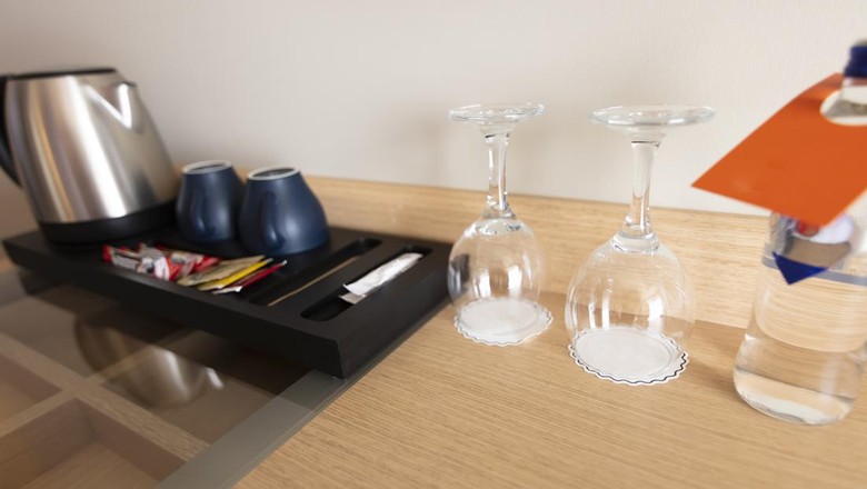 Gelas di kamar hotel Cup of coffee placing on a wooden small table in hotel room