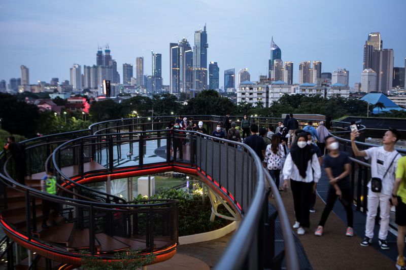 Pengunjung melihat pemandangan dari Skywalk Senayan Park, Jakarta, Senin (27/12/2021). Kawasan tersebut menjadi salah satu objek wisata ibu kota yang ramai dikunjungi oleh warga dengan menyajikan pemandangan lanskap perkotaan. ANTARA FOTO/Fauzan/hp.