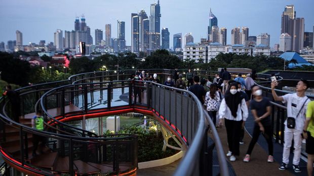 Pengunjung melihat pemandangan dari Skywalk Senayan Park, Jakarta, Senin (27/12/2021). Kawasan tersebut menjadi salah satu objek wisata ibu kota yang ramai dikunjungi oleh warga dengan menyajikan pemandangan lanskap perkotaan. ANTARA FOTO/Fauzan/hp.