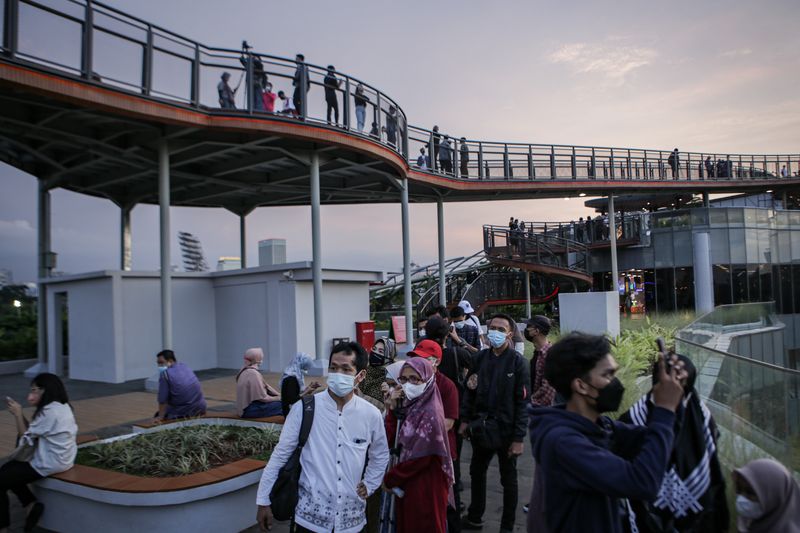 Pengunjung melihat pemandangan dari Skywalk Senayan Park, Jakarta, Senin (27/12/2021). Kawasan tersebut menjadi salah satu objek wisata ibu kota yang ramai dikunjungi oleh warga dengan menyajikan pemandangan lanskap perkotaan. ANTARA FOTO/Fauzan/hp.