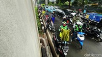 Derasnya hujan memaksa mereka berteduh di bawah kolong jembatan tersebut meski sudah ada peraturan yang melarangnya.