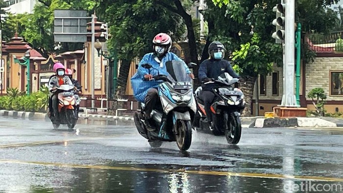 Sejumlah pengendara motor berteduh di kolong jembatan layang bus TransJakarta, Selasa (28/12/2021). Meski membuat lalu lintas macet, mereka nekat berteduh agar terhindar dari guyuran hujan.