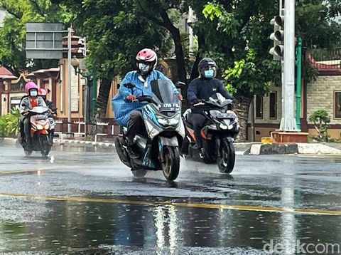Sejumlah pengendara motor berteduh di kolong jembatan layang bus TransJakarta, Selasa (28/12/2021). Meski membuat lalu lintas macet, mereka nekat berteduh agar terhindar dari guyuran hujan.