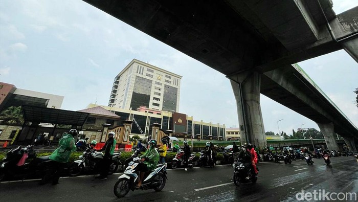 Pengendara Motor Neduh di Kolong Jembatan Bikin Macet Sejumlah pengendara motor berteduh di kolong jembatan layang bus TransJakarta, Selasa (28/12/2021). Meski membuat lalu lintas macet, mereka nekat berteduh agar terhindar dari guyuran hujan.