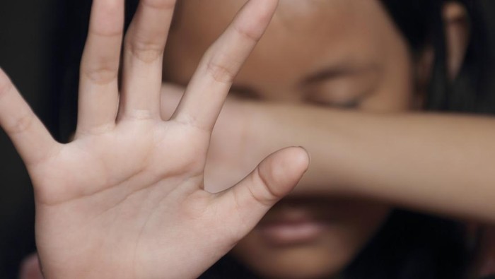 Little girl suffering bullying raises her palm asking to stop the violence