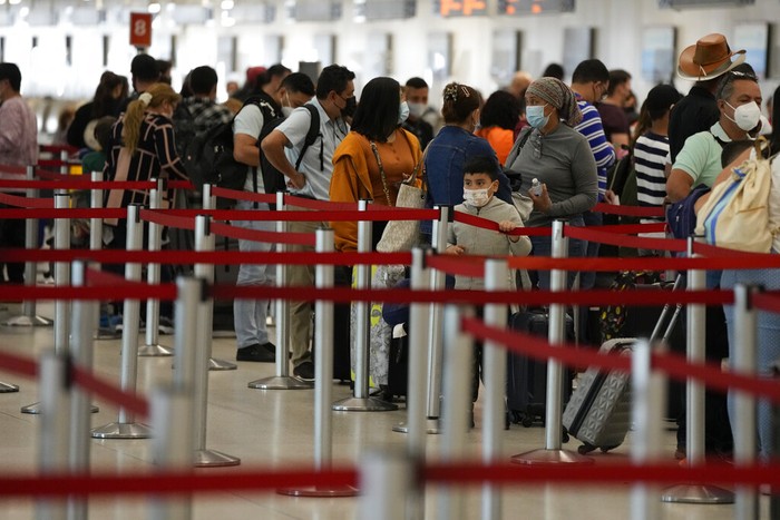 Pelancong menunggu di antrean check-in di Bandara Internasional Miami, Senin, 27 Desember 2021, di Miami. Ribuan penerbangan di seluruh dunia dibatalkan atau ditunda pada hari Senin, karena kekurangan staf maskapai karena penyebaran cepat varian omicron dari COVID-19 terus mengganggu musim perjalanan liburan yang sibuk. (Foto AP/Rebecca Blackwell)