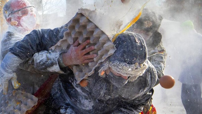 Serunya Saling Lempar Tepung dan Telur di Festival Spanyol Revellers take part in the Els Enfarinats festival, in the town of Ibi near Alicante, Spain, Tuesday Dec. 28, 2021. For about 200-years the inhabitants of Ibi annually celebrate with a battle using flour, eggs and firecrackers, outside the city town hall. (AP Photo/Alberto Saiz)