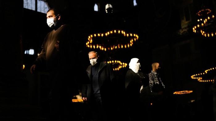 Waspada! 10% Kasus Baru di Turki Disebabkan Omicron Worshippers and visitors, wearing protective face masks to prevent the spread of COVID-19, arrive to Byzantine-era Hagia Sophia mosque, in Istanbul, Turkey, Monday, Dec. 27, 2021. Turkey's Health Minister Fahrettin Koca said the highly contagious Omicron variant now makes up for more than 10 percent of new cases in the country's crowded provinces. (AP Photo/Francisco Seco)