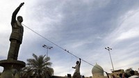 Kerumunan warga mencoba merobohkan patung Presiden Saddan Hussein (12/4/2003) di Baghdad, Irak (12/4/2003). Saddam menjadi Presiden Irak sepanjang 1979 hingga 2003. (Photo by Scott Nelson/Getty Images)