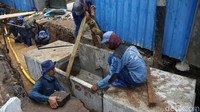 Sekitar 15 petugas pasukan biru bahu membahu membuat gorong-gorong sepanjang kurang lebih 100 meter.
