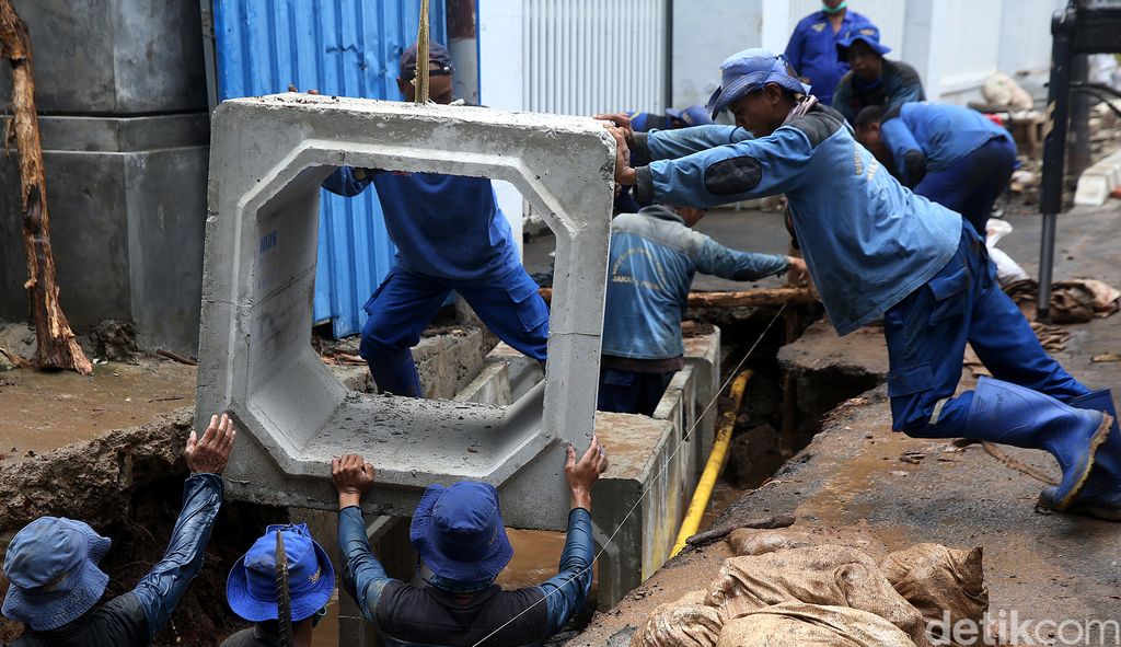 Sejumlah pasukan biru memasang box culvert ke dalam gorong-gorong di Jalan Teuku Umar, Menteng, Jakarta. Pembuatan gorong-gorong ini dilakukan guna atasi banjir