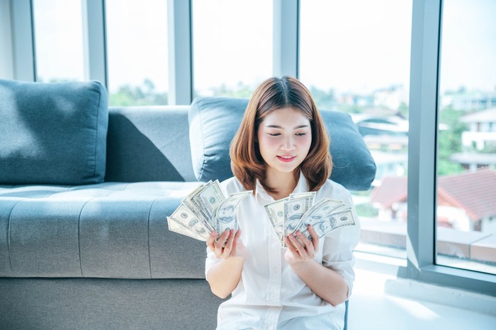Ilustrasi Cancer di 2022 Happy young asian woman holding dollar money and throw in the air celebrate happiness dance wealth lottery money rain drop. Winner Success business woman throw cash flow Happy money smiling face