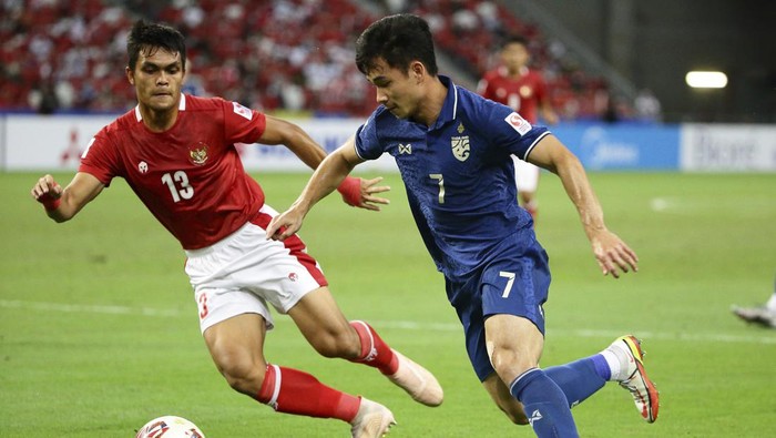 Supachok Sarachat of Thailand, right, controls the ball against Rachmat Irianto of Indonesia during the AFF Suzuki Cup 2020 final first leg soccer match between Indonesia and Thailand in Singapore, Wednesday, Dec. 29, 2021. (AP Photo/Suhaimi Abdullah)