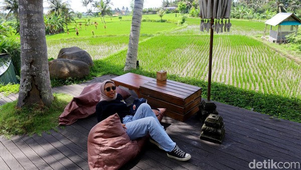 Nih, kalo nggak percaya. Namanya, Kafe Kelapa Muda yang ada di Ubud, Bali yang menawarkan konsep kembali ke alam. Asyik banget bukan? Pengunjung yang satu ini aja tampak bersantai di pinggir sawah.