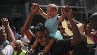 Seorang pria menari dengan putrinya selama perayaan Hari Tak Bersalah.