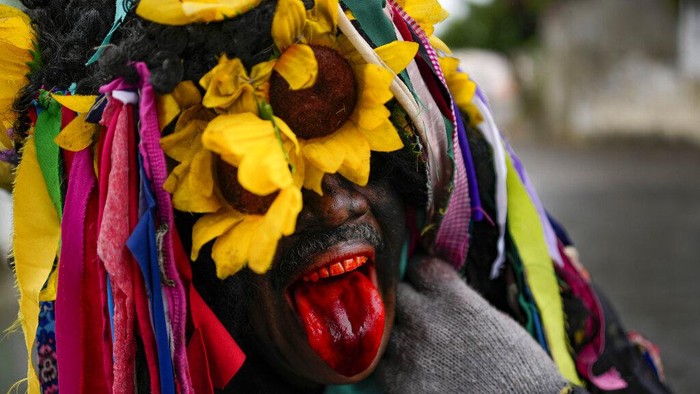 Orang-orang mengambil bagian dalam perayaan Hari Suci Tak Bersalah di Caucagua, Venezuela, Selasa, 28 Desember 2021. Warga merayakan variasi hari raya itu dengan mengenakan pakaian tua, mengecat wajah mereka hitam dan lidah merah. Tradisi berusia lebih dari 200 tahun adalah hari nyanyian, tarian, dan lelucon. (Foto AP/Matias Delacroix)